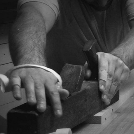 Artigiano al lavoro su sedia campagnola in legno