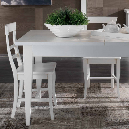 Sedia leggera con fondino in legno accanto a tavolo bianco