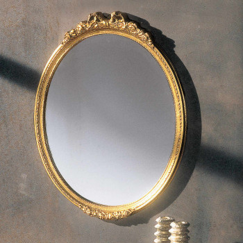 Specchiera ovale dorata con cornice intagliata a rilievo