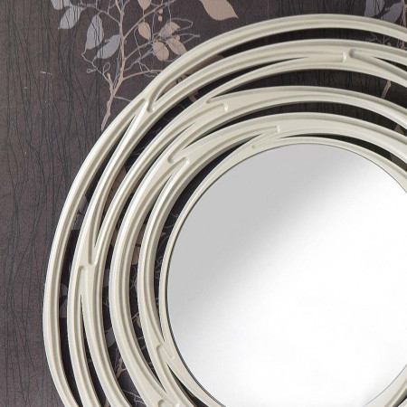 Specchiera rotonda traforata a vortice su sfondo decorativo