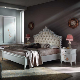 Letto con testata imbottita e dettagli intagliati Letto con testata imbottita e decori classici, dettaglio testata
