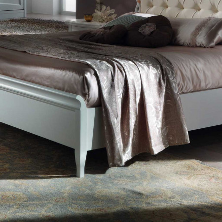 Letto con testata imbottita e decori, dettaglio capitonnè