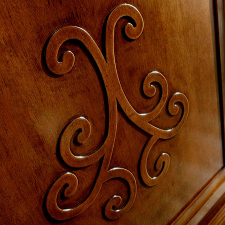 Dettaglio rilievo a giglio su credenza in legno