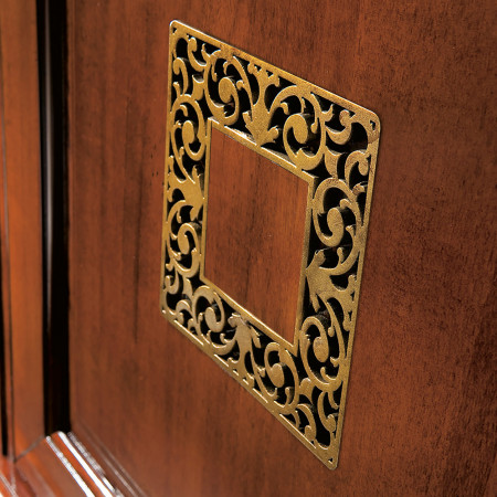 Dettaglio bugna traforata oro su credenza legno