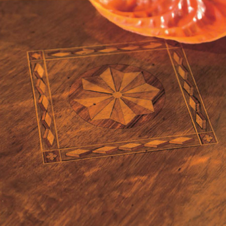 Dettaglio intarsio tavolo modello Stella legno noce