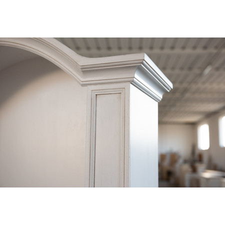 Dettaglio libreria bianco patinato con cornice intagliata