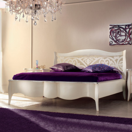 Letto a due piazze in legno con testata traforata e dettagli eleganti