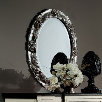 Specchiera ovale argentata con intagli floreali in dettaglio