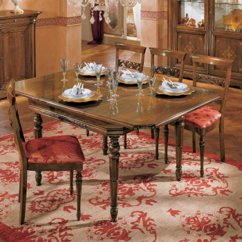 Tavolo quadrato allungabile apparecchiato su tappeto rosso