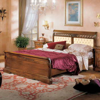 Letto in legno massello con pannelli capitonè e intaglio