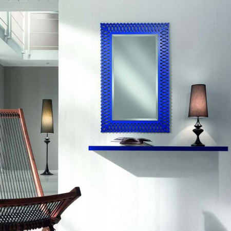 Specchio con cornice traforata blu su parete chiara