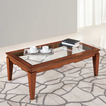 Tavolino con piano in vetro trasparente su tappeto decorato