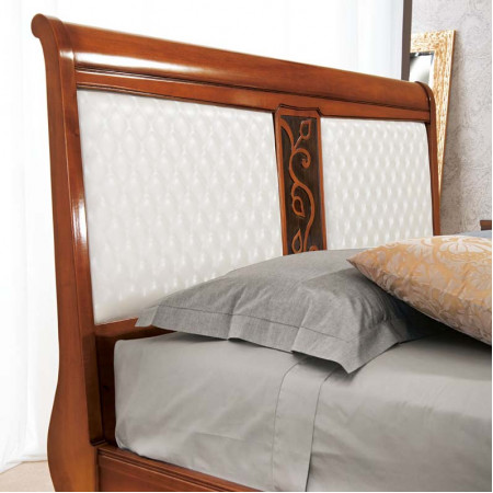 Letto con piedini, dettaglio testata imbottita con intaglio floreale