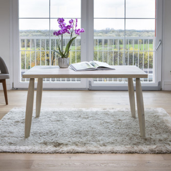 Tavolo moderno in legno con piano bordo dritto e gambe tornite, ambientato in soggiorno luminoso