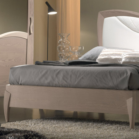 Letto matrimoniale sagomato con testata imbottita, dettaglio dell'intaglio