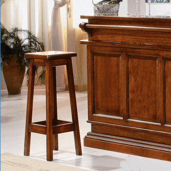 Sgabello tinta noce in legno massello accanto a bancone
