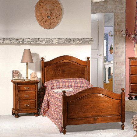 Comodino classico in legno con 3 cassetti vicino al letto