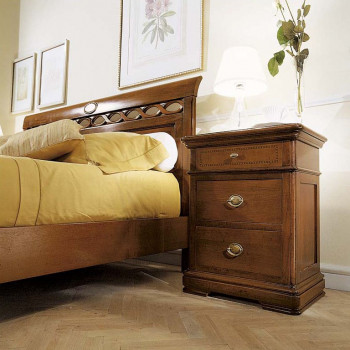 Comodino tre cassetti con filetto accanto a letto