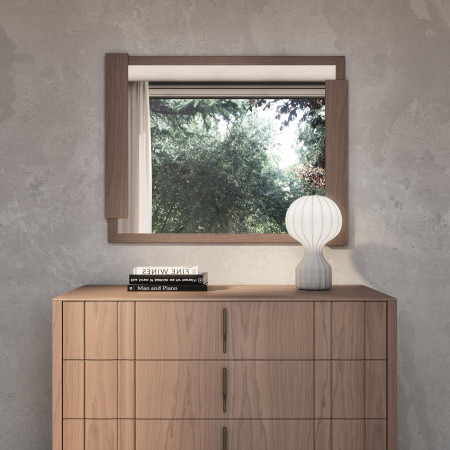 Specchiera in legno con cornice asimmetrica, vista su ambiente naturale