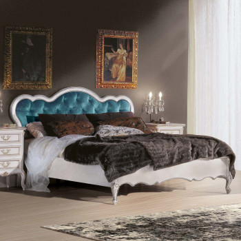Letto imbottito con particolari intagliati, testata capitonnè blu
