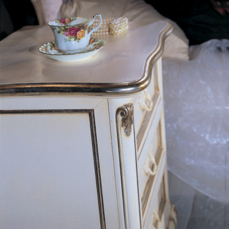 Comodino 3 cassetti con dettagli intagliati e tazza floreale