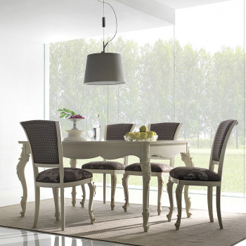 Tavolo allungabile sagomato ambientato con sedie intagliate