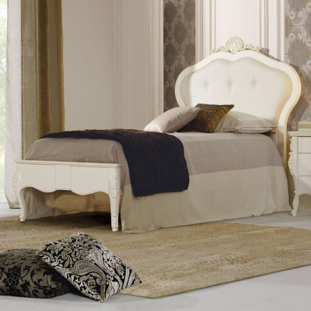 Letto singolo in legno con testata imbottita e intaglio