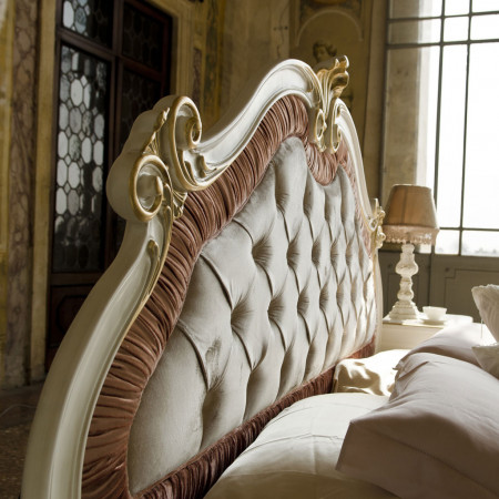 Letto classico con testiera intagliata in legno e tessuto